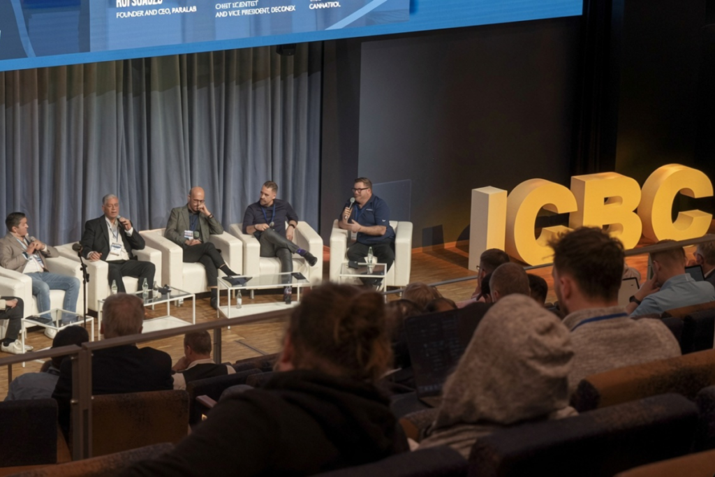 ICBC Berlin 2026 Cannabis B2B Trade Showのパネルディスカッション。ステージ上で5人のスピーカーが白いソファに座り、聴衆の前で議論を行っている様子。右端の男性がマイクを持ち話しており、背景に大きな黄色のICBCロゴとスクリーンが映っている。