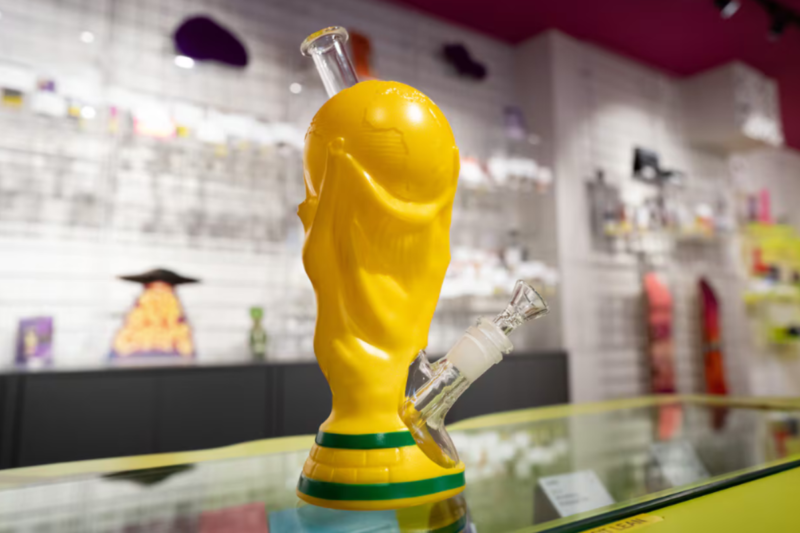 トロフィー型の金色ボングが大麻ショップ店内のガラスケース上に展示されている様子