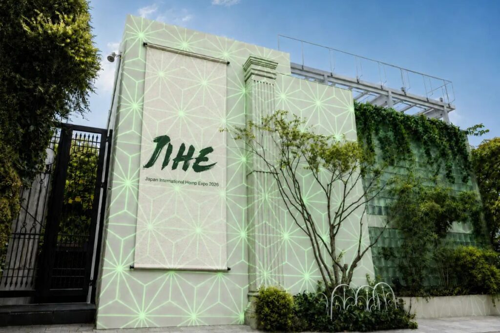 日本国際ヘンプ博覧会2026 (JIHE) の建物外観。緑色の幾何学模様の壁に大きなJIHEロゴと『Japan International Hemp Expo 2026』の文字が表示されている。